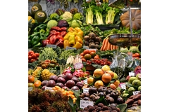 Image Lots of fruits and vegetables on display at an outdoor market.