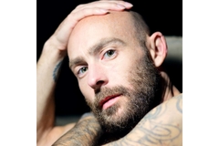 bald man posing with hand on head.
