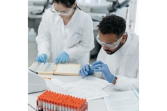 Two people in a laboratory with white coats doing research.