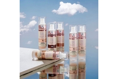 A collection of products by beauty brand Revolution Beauty against the backdrop of a cloudy blue sky.