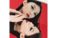 Image An Asian woman wearing makeup strikes a pose in front of a mirror.