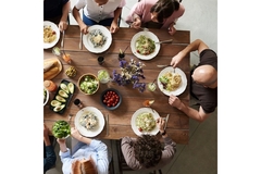 Image People eating different types of vegetables and dishes around a table.