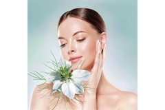 Image A woman with healthy skin poses with an exotic flower.