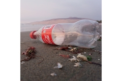 Coca-Cola bottle on beach.