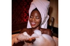 Woman in bathtub surrounded with foam.