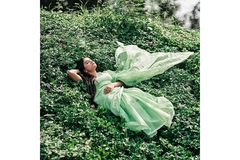 Image Woman in sari laying on lush green plants