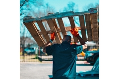 man lifting a wooden pallet above his head