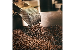 Image Coffee beans falling into a roaster.