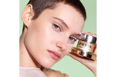 Image A female model holds up a jar of Prada's new skin cream from the brand Prada Skin.