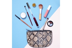Image Pouch with several make up products floating above it