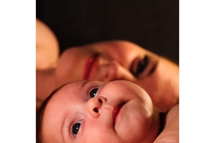 Image Woman and baby laying down next to eachother smiling