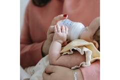 Image Baby eating formula from a bottle.