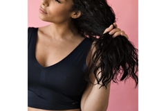A woman runs her fingers through her hair.