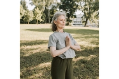 Older woman doing yoga in a park.