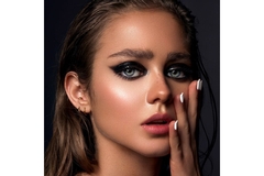 girl with slicked back hair posing with heavy eye makeup