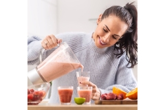 Image Woman pouring smoothie into cups