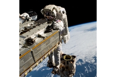 Image Astronaut holding space material above Earth.