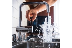 Image tap water overflows a glass on kitchen sink