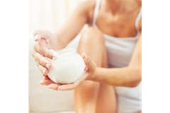 Image A woman applying skin cream to her leg.
