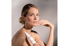 Image A woman modeling with a tube of face cream by the brand Skin Virtue.