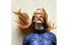 Image Girl's fine straight hair being blown by the wind to the left.