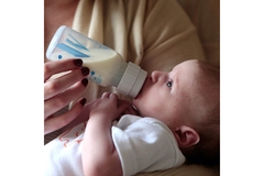 Image A baby feeding on a bottle.