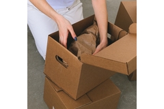 Image Hands putting crumpled paper into a cardboard box.