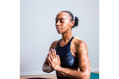 black woman with palms together looking zen