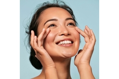 Image A woman looks at the sun and has clear skin.