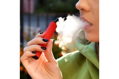 woman releasing smoke from a single-use vape