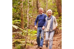 Older couple walking through the woods.