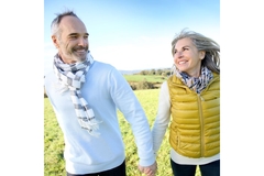 Image Older man and woman holding hands, walking outside.