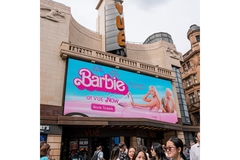 A Barbie movie poster in on top of a theater.