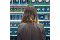 A woman looking at a shelf with amcor products on the shelf.