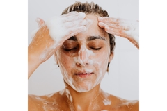 Image A woman washing her face with a lot of bubbles.