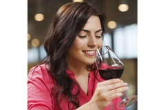 A woman drinking wine from a glass.