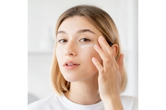 Image A woman applying eye cream.