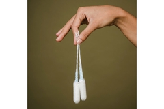 Image A hand holding two tampons.