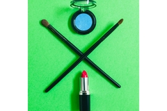 Image A pot of eyeshadow on top and a lipstick on the bottom with two makeup brushes making an X.