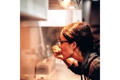 Image A lady is tasting something from a spoon.