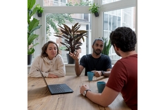 Image A group of people meeting and talking in a board room.