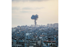 Image A boom landed in a city with smoke going up.