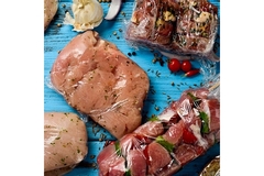 Different types of meat covered in transparent plastic.