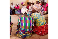 Image A group of women sitting around working in a shea nut factory.