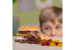 Image Child looks at unhealthy snacks.