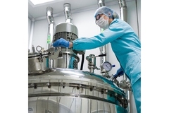 Scientist working with a bioreactor in factory.