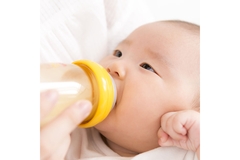 Image Baby drinking from a bottle.