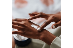 Image A woman applies hand cream.