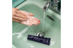 Image Hands washing in a green sink with a Curology bottle in the sink.