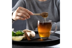 A man pouring honey in tea.